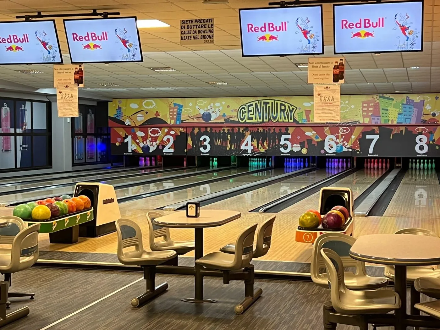 Le piste da bowling del Century, con il murale e i tavolini davanti
